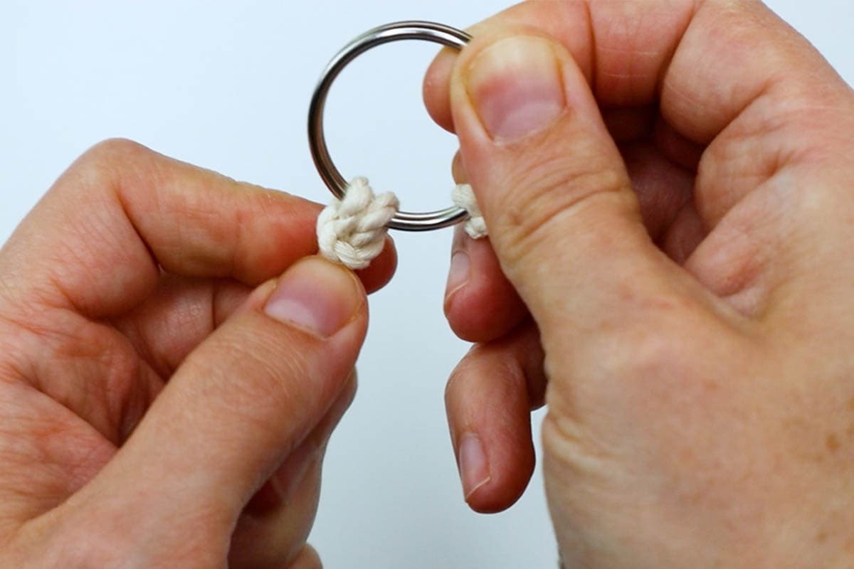 attaching a cord to the metal ring with a lark's head knot