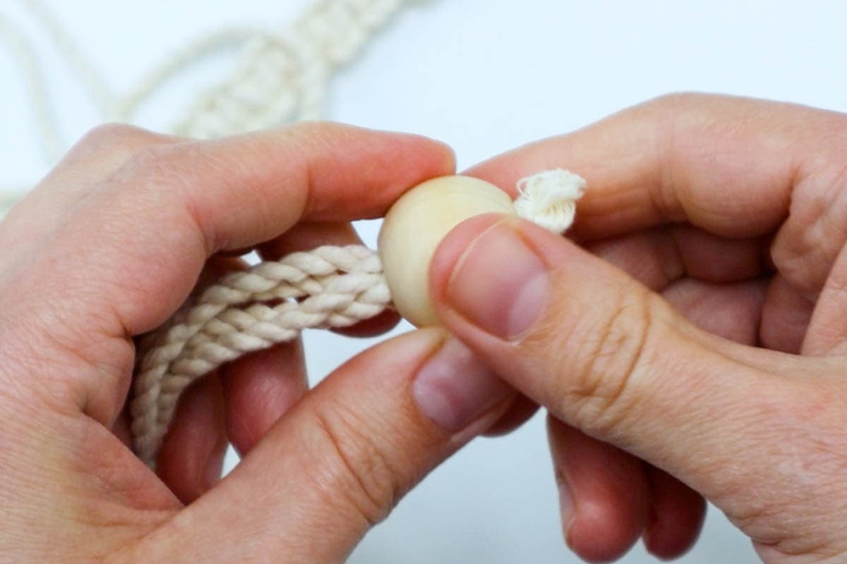 thread the wooden bead onto the cords