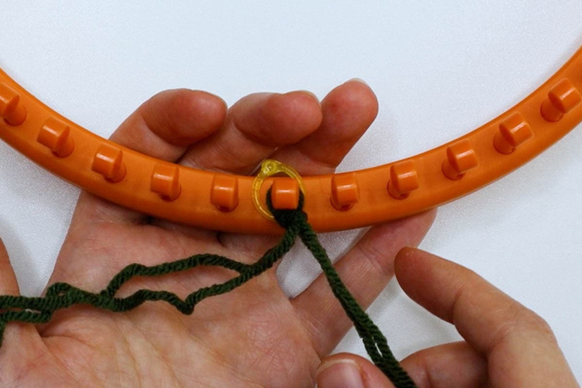 place loop from slip knot on first peg