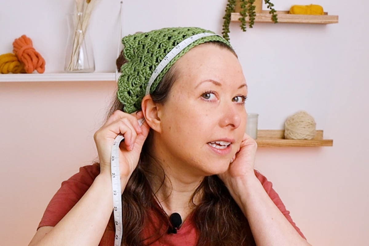 Crystal from Marching North measuring with a tape measure behind each ear