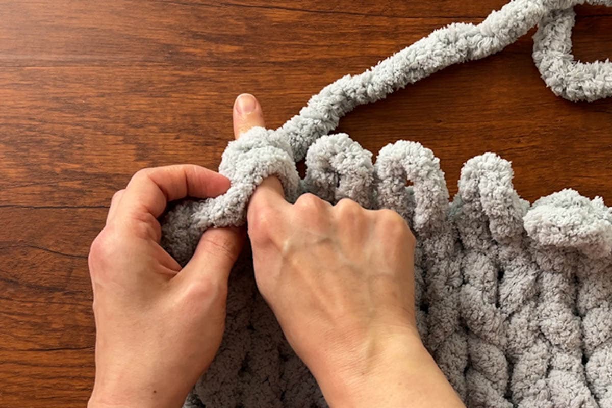 Insert fingers through the 2 loops and grab your working yarn