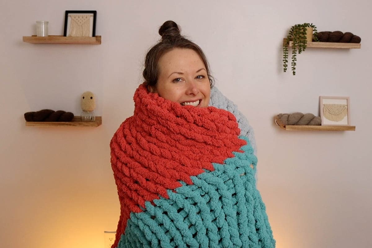 Crystal from Marching North wrapped up in finger knit blanket and smiling