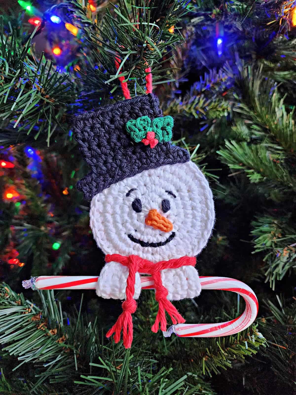 a crochet snowman candy cane holder ornament