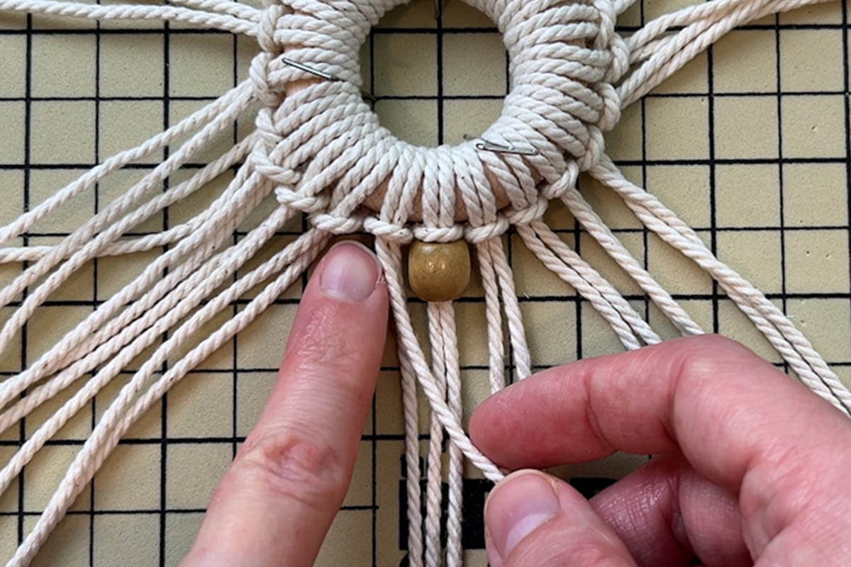 tying first row of double half hitch knots for one snowflake point