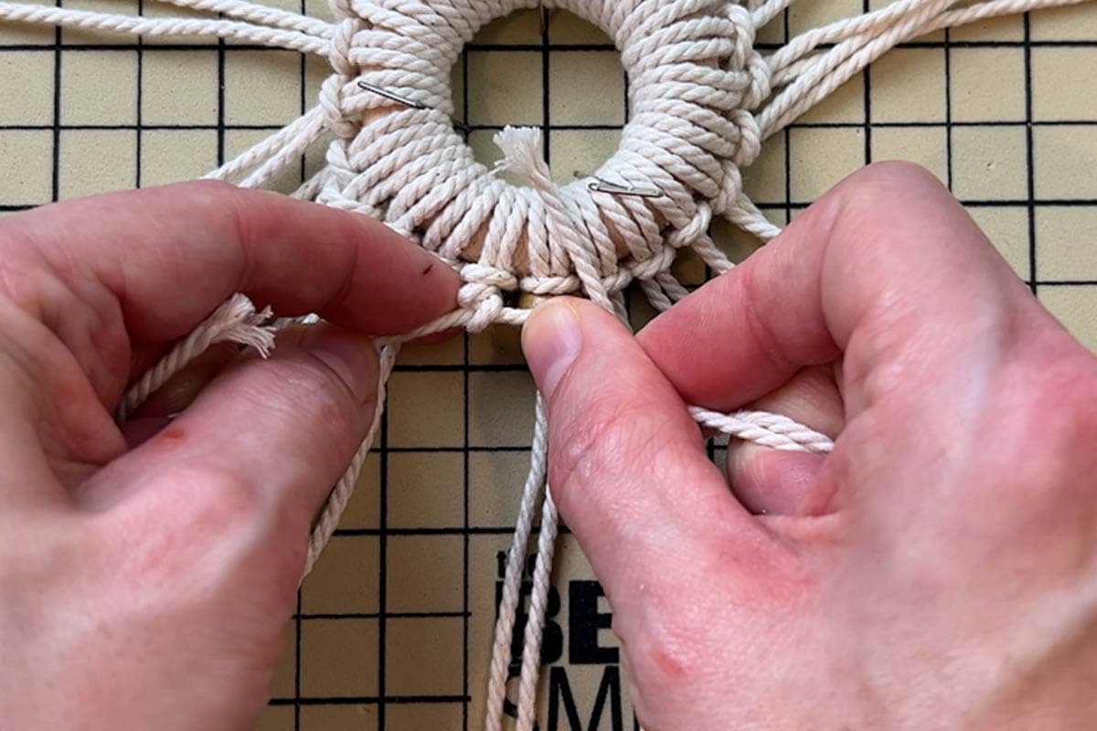 tying first row of double half hitch knots for one snowflake point