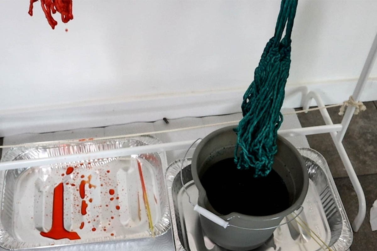 pulling the blue plant hanger out of the dye bucket
