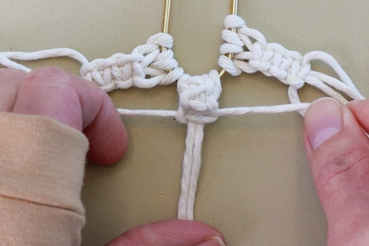 tying a square knot under the first berry knot