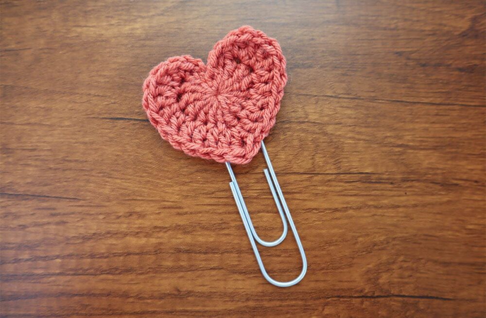 red medium sized heart made into a bookmark using a large paperclip