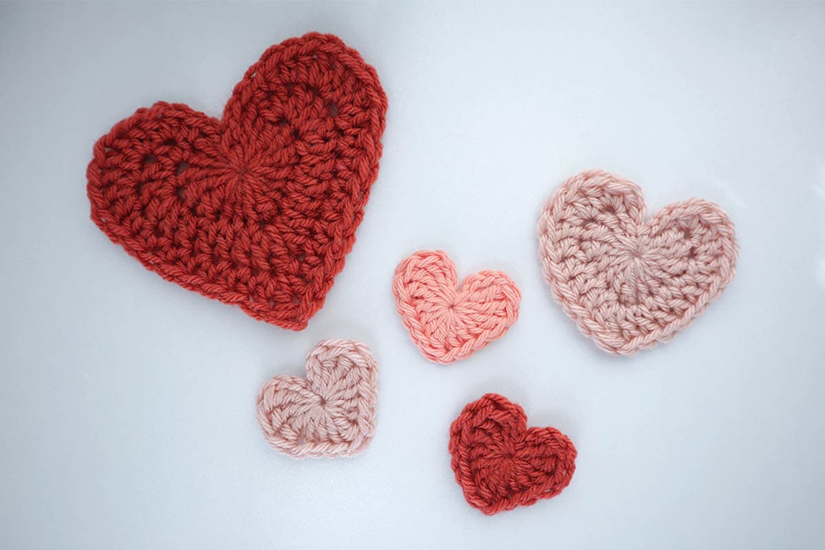 finished crochet hearts on a white desk