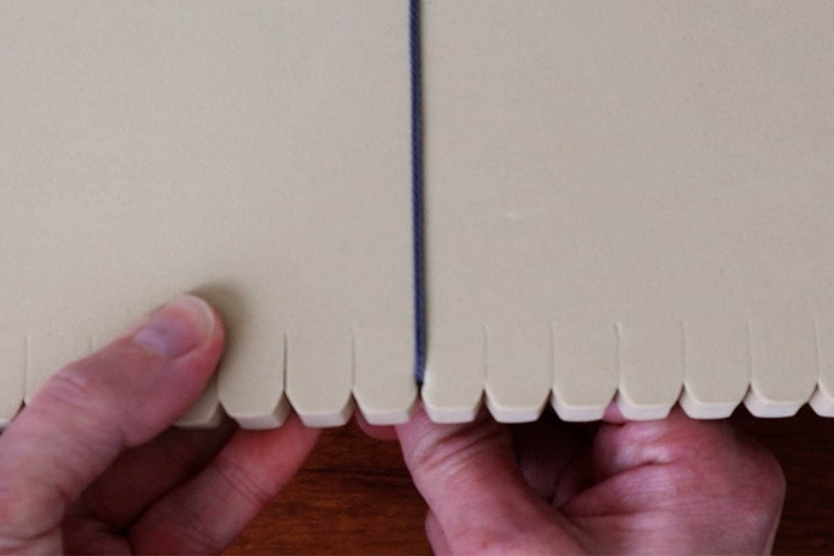 inserting the other end into the bottom of the macrame board