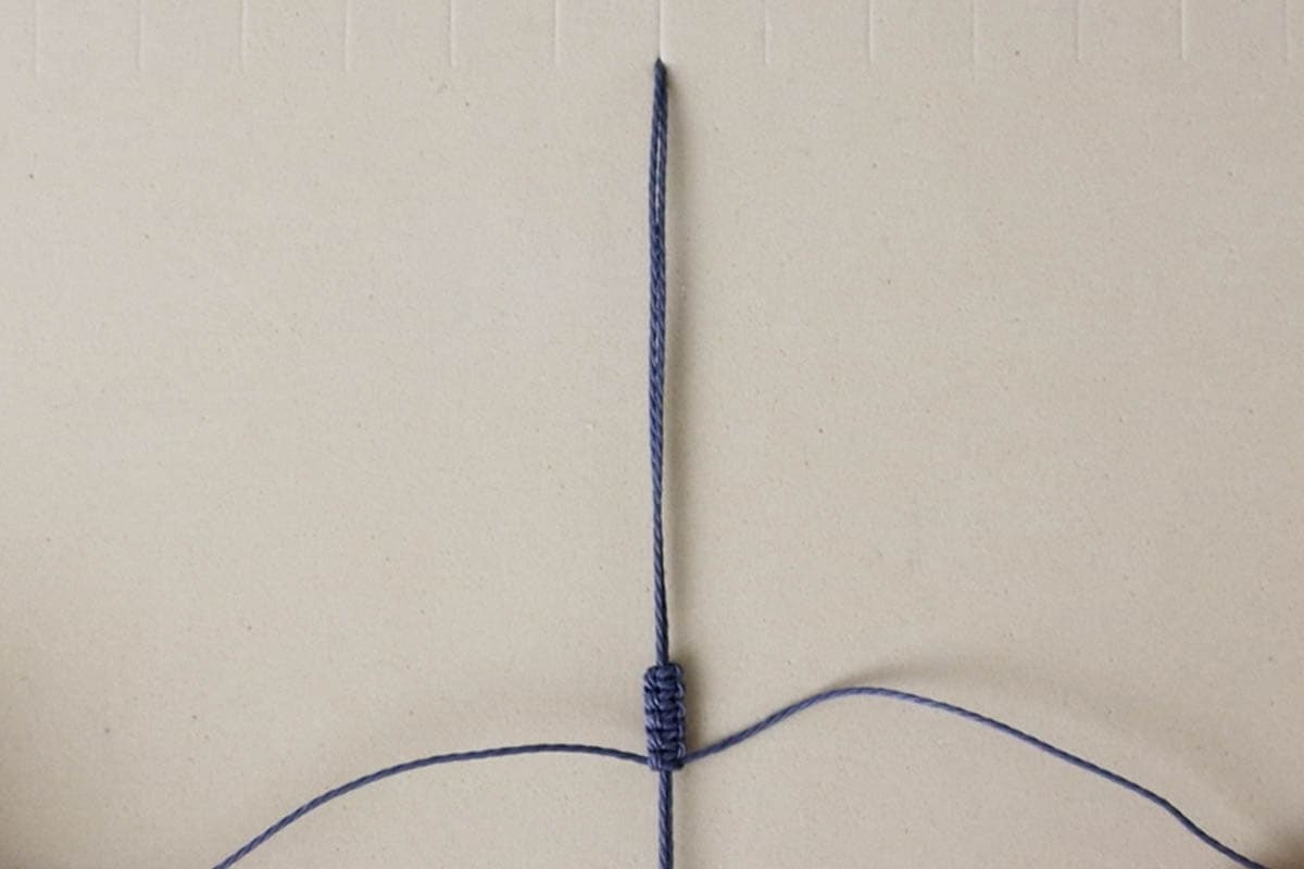 5 square knots tied and at least 5 inches of space in the filler cords before that