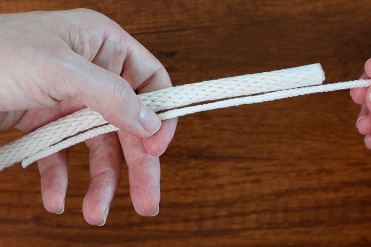 holding the wrapping cord next to the filler cord to start the basket